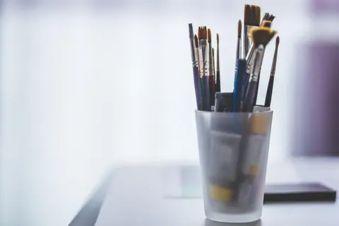 Pinceaux dans un verre, sur une table d'atelier