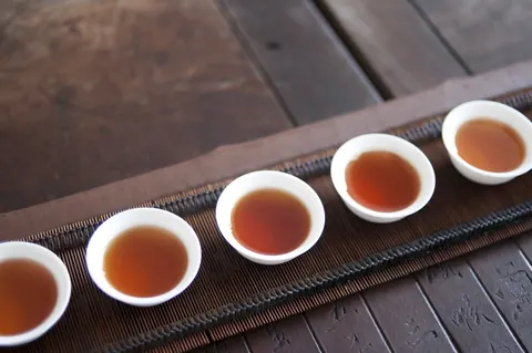 Tasses de thé alignées sur un plateau de bois
